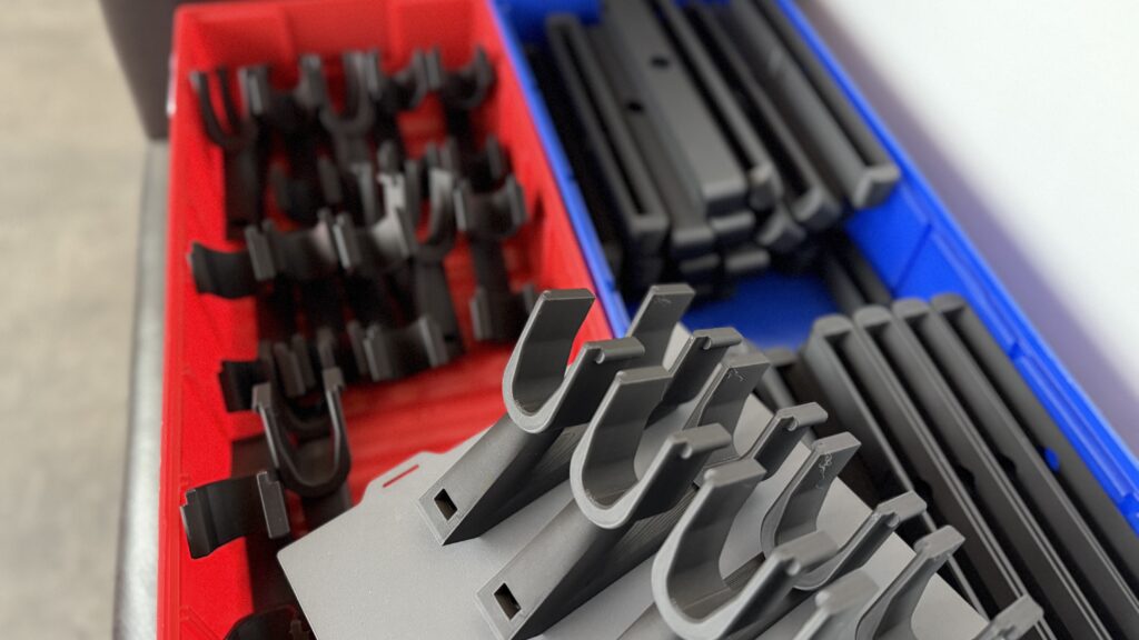 Schwarze Kunststoffteile in Kisten, Serienproduktion, PLA 